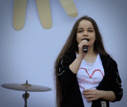 Zdjęcie, śpiewająca dziewczyna w trakcie występu