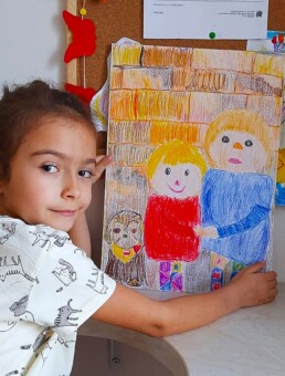 Zdjęcie, dziewczynka prezentująca swój rysunek