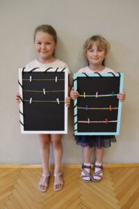 Dwie dziewczynki z tablicami ze sznureczkami z klamerkami 