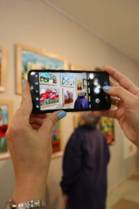 Zdjęcie ludzkim dłoni, które trzymają telefon, który robi zdjęcie wystawie 