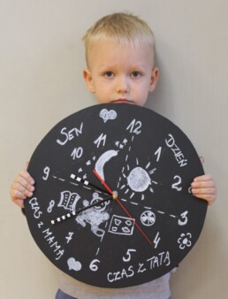 Zdjęcie, małe dziecko trzymające zegar