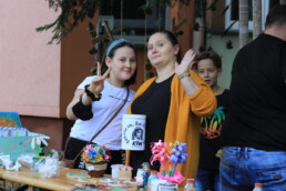 Zdjęcie, kobieta i dziewczyna pozujące przy straganie z rękodziełem