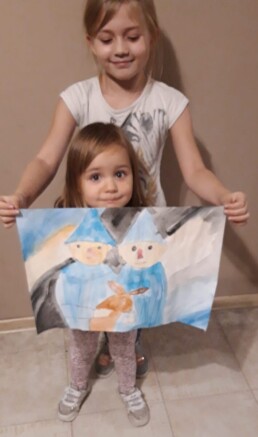 Zdjęcie, dwie dziewczynki prezentują rysunek