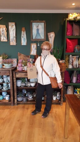 Zdjęcie, kobieta w sklepie z rękodziełem; trzyma papierową torebkę