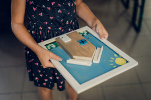 Dziewczynka trzyma w ręce drewniany obrazek 
