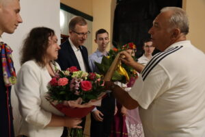 Na zdjęciu Jan Mańka wręcza kwiaty przybyłym gościom 
